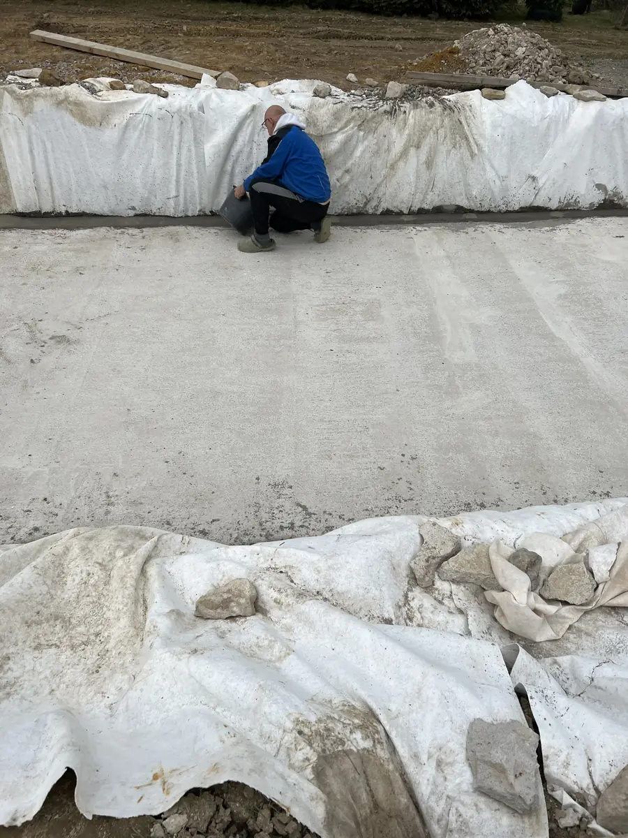 Práce na betonové desce bazénu — finišování povrchu betonu, Berounsko
