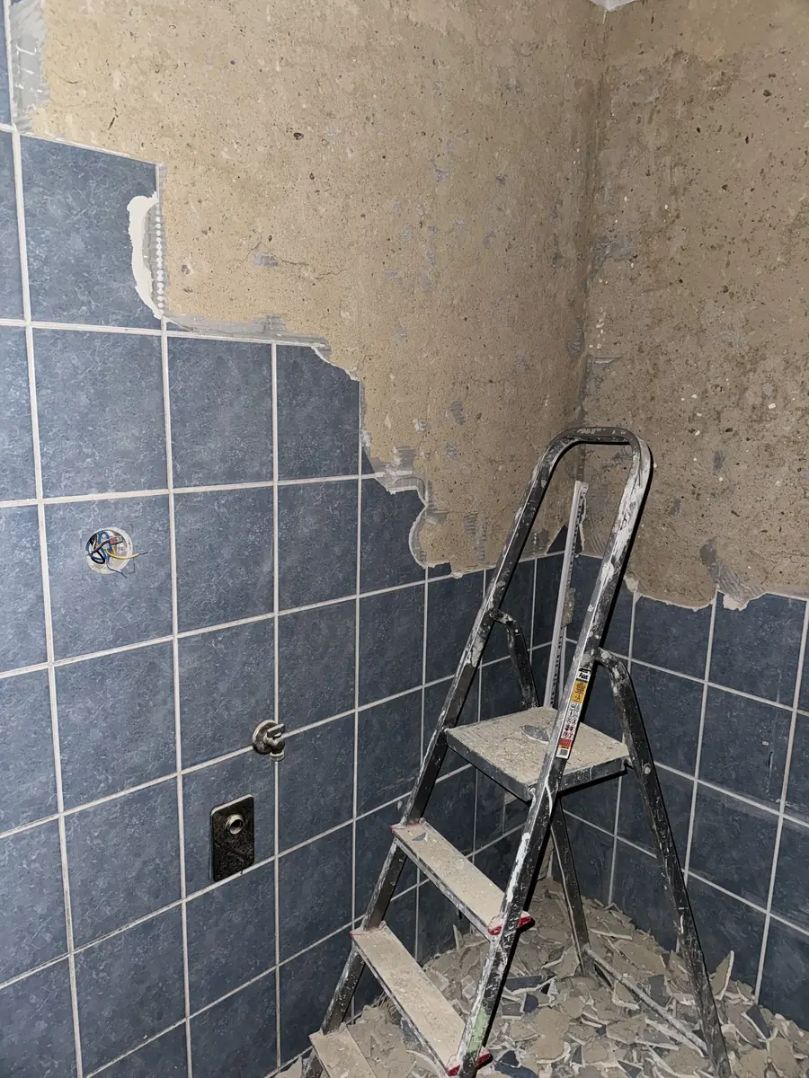 Rekonstrukce koupelny v průběhu prací — nové obklady a žebřík