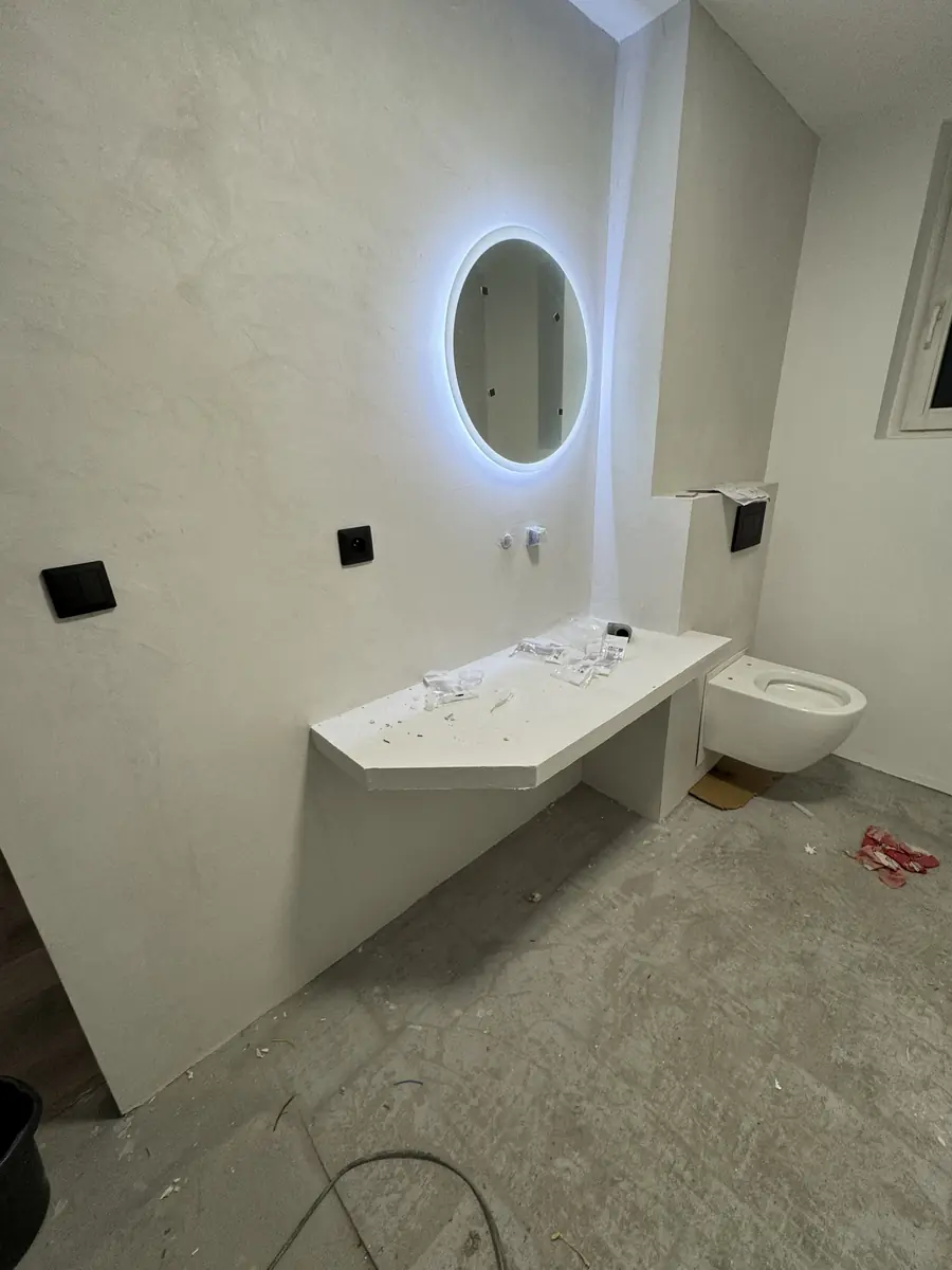 Hotová moderní koupelna — LED zrcadlo, rohový pult a závěsné WC, Berounsko